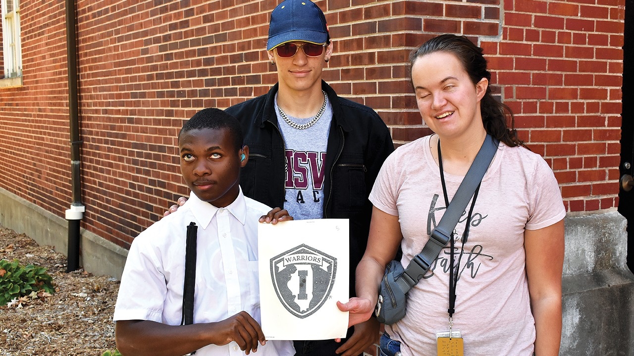 3 ISVI Students hold a picture of our new School Logo
