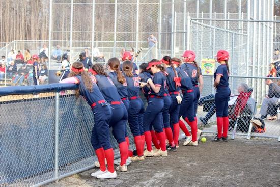 Photo of the Patriot Pioneers Varsity softball team in the dugout at Colgan.